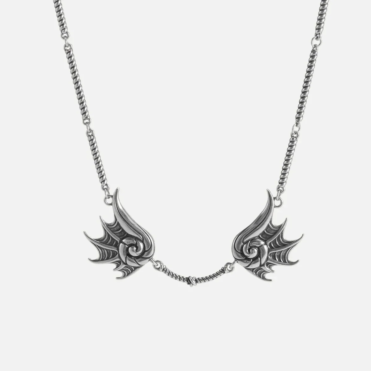 Silver Abyssal Bind Necklace with twin conch-like forms, shell ridges, central rope chain detail, and antiqued finish on a clean background.