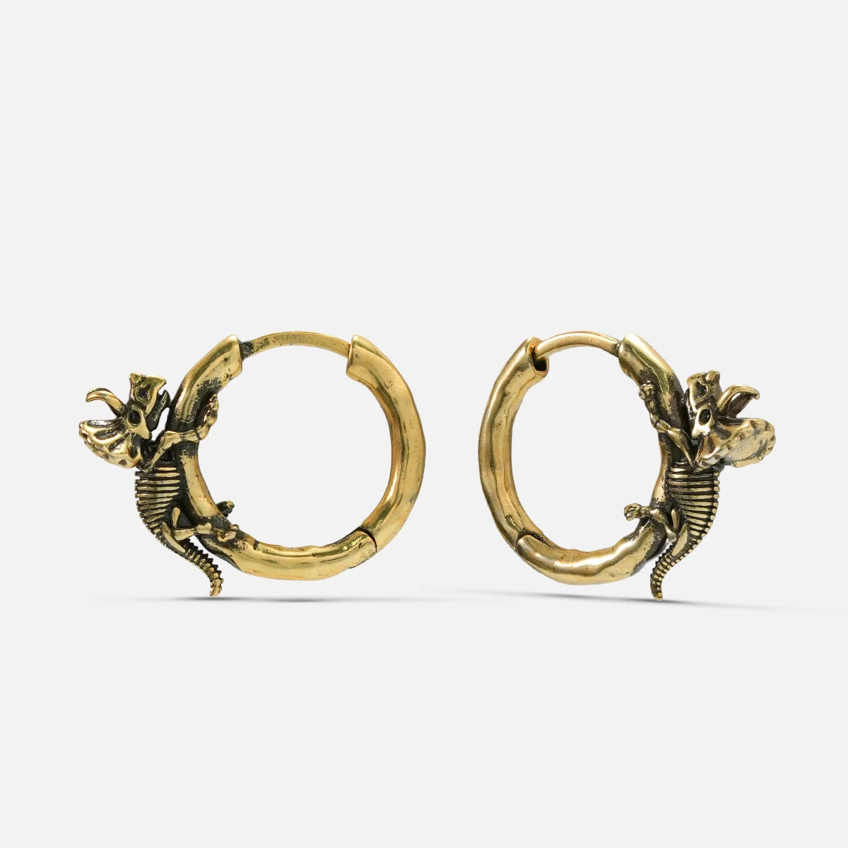 Pair of gold Adaptive Evolution hoop earrings with small skeletal creature details