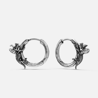Silver-tone Adaptive Evolution hoop earrings with dinosaur skeletons wrapped along the hoops