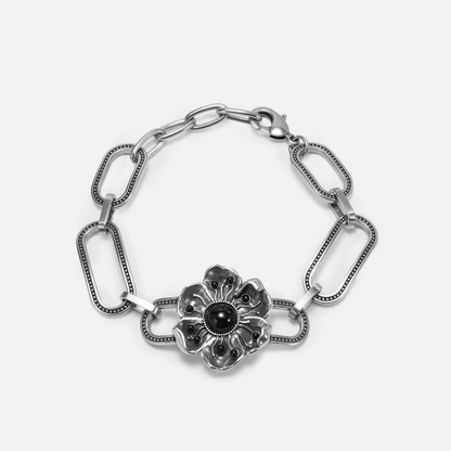 Silver-tone bracelet with paperclip chain links and a flower charm centered with a black stone