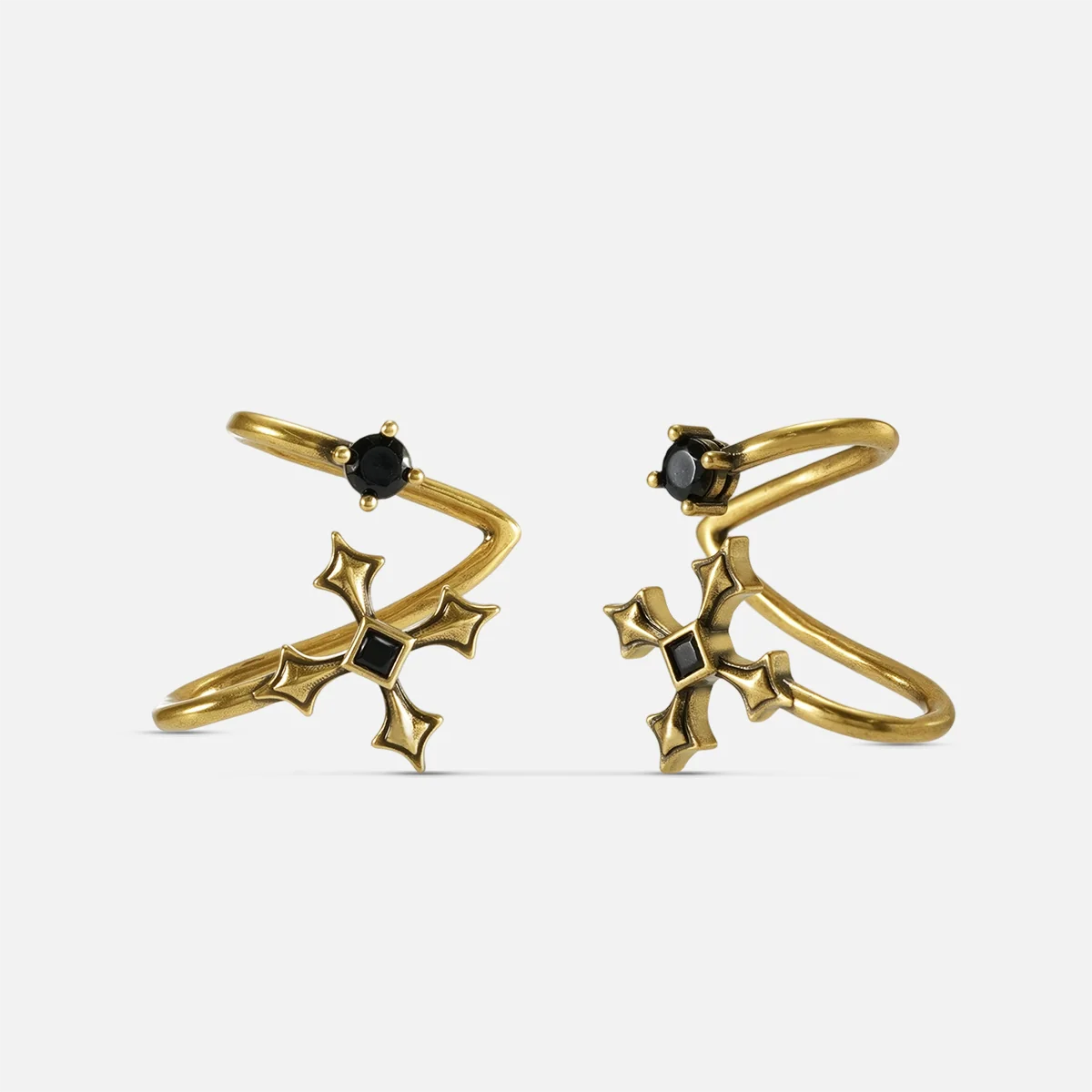 Bound Vestige Ear Cuffs in antiqued 18K gold with black obsidian and cross-inspired metalwork on a white background.