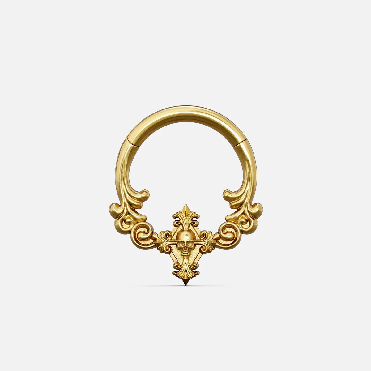 Gold-tone septum clicker ring with ornate scrollwork and a small skull motif, front view on white background
