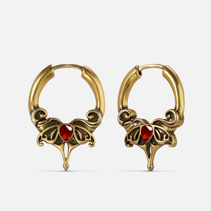 Gold-tone Crimson Wing hoop earrings with red teardrop stones and ornate pointed wing details