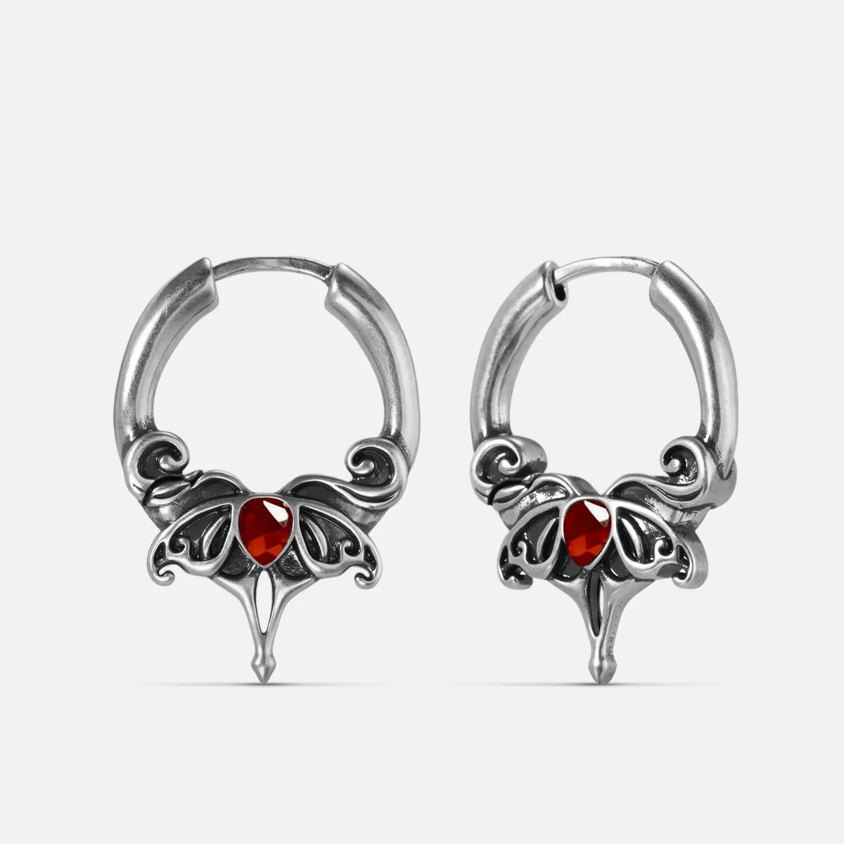 Silver-tone Crimson Wing hoop earrings with red teardrop stones, scrolling wings, and pointed drops