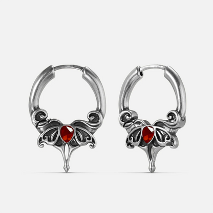 Silver-tone Crimson Wing hoop earrings with red teardrop stones, scrolling wings, and pointed drops