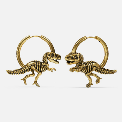 Pair of gold-tone hoop earrings featuring detailed dinosaur skeleton charms, shown side by side on a plain background