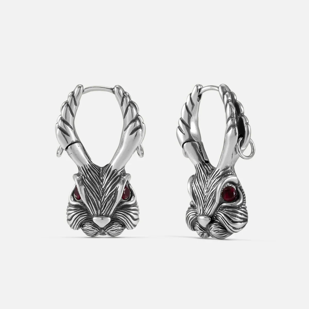 Pair of oxidized silver-tone jackalope hoop earrings with antlers and red gemstone eyes, front view
