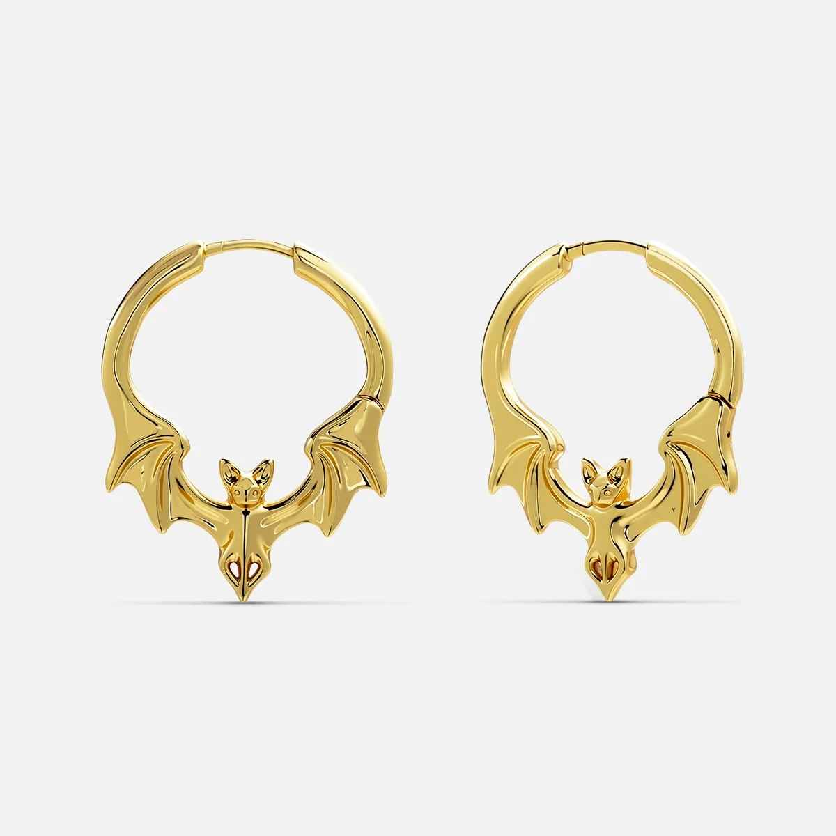 Pair of gold-tone bat hoop earrings with spread wings, front view on white background