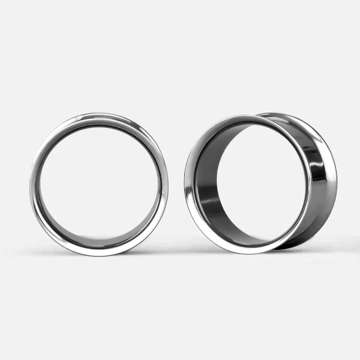 Pair of minimalist loop titanium tunnels shown front and side facing on a plain background