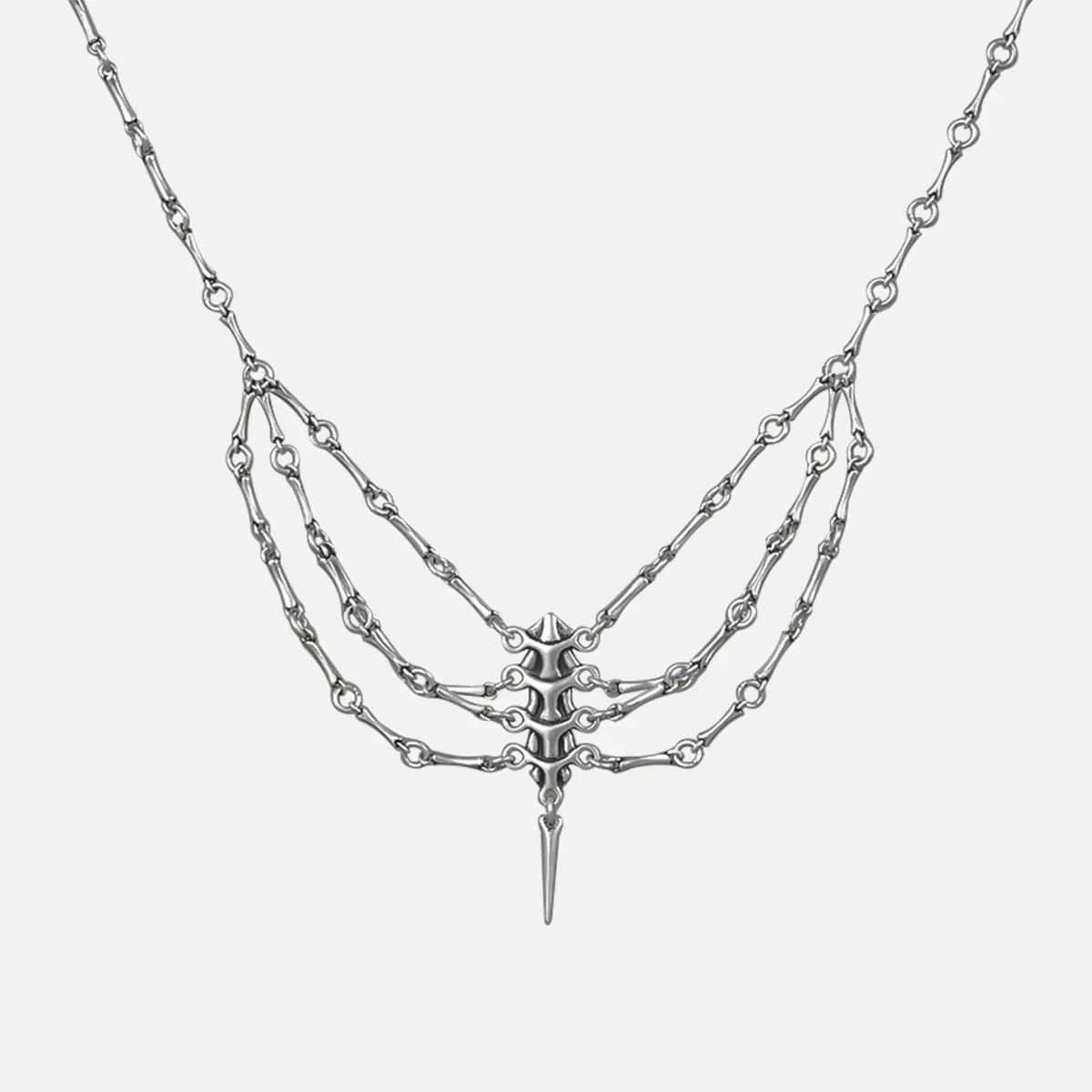 Silver-tone spine necklace with layered chains and a spike pendant, shown flat on a plain background