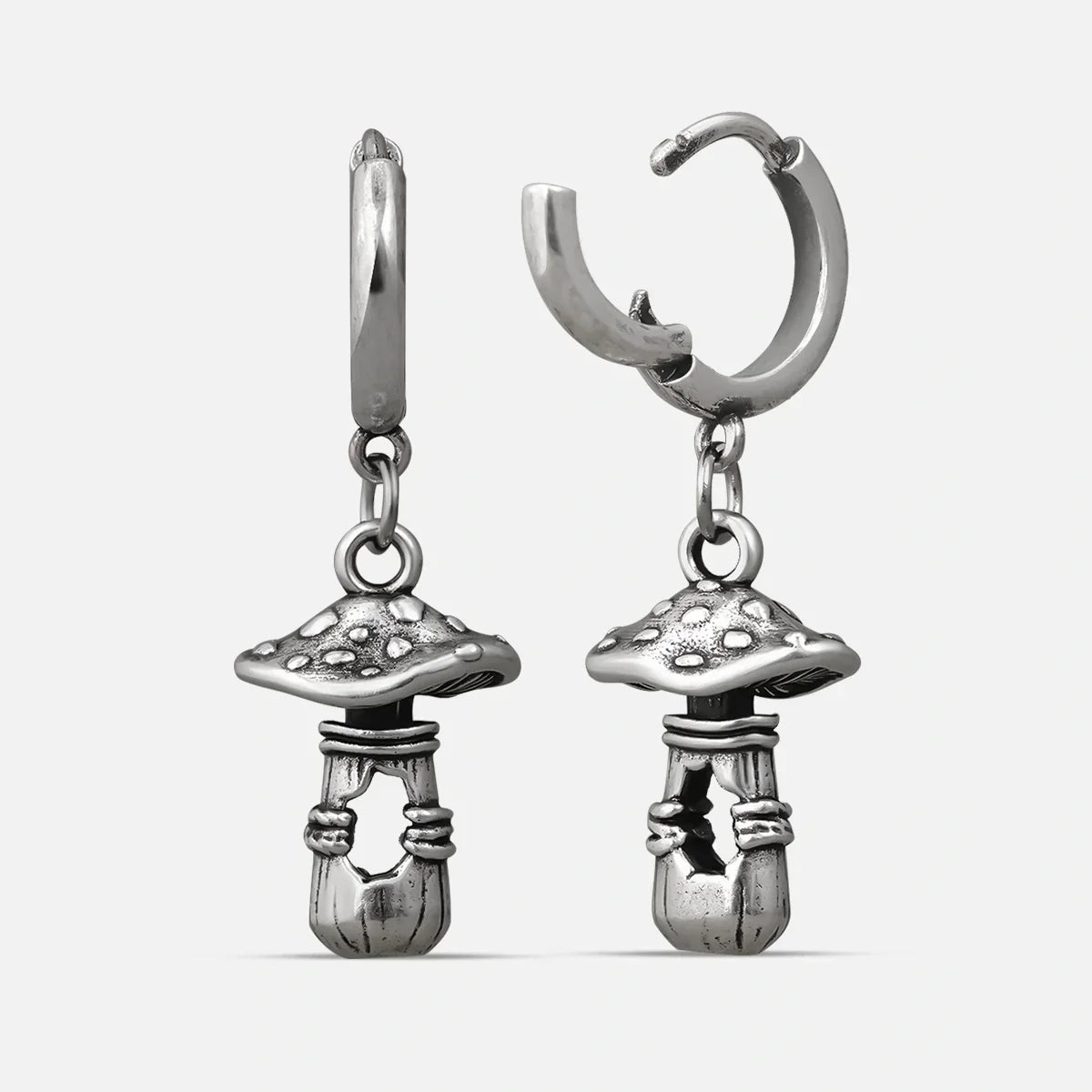 Silver-tone huggie hoop earrings with dangling textured mushroom charms, shown as a matching pair