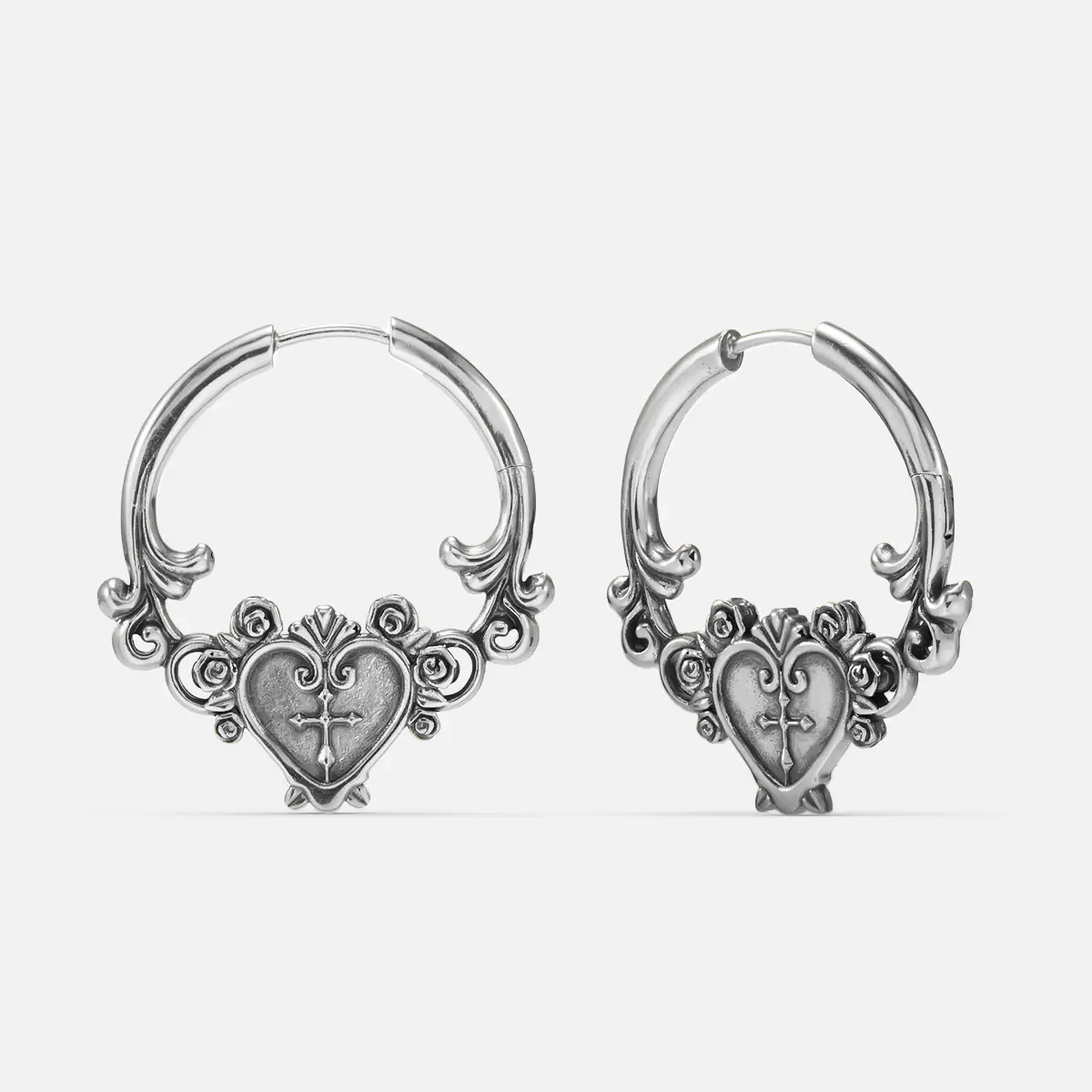 Ornate Affection Earrings in 925 sterling silver, pair shown on white, featuring scrollwork hoops with a sculpted sacred-hear