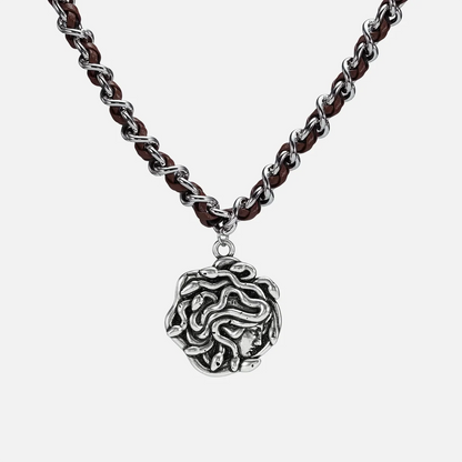 petrified power necklace in silver shown in a front close-up view, featuring a medusa-inspired pendant on a braided chain