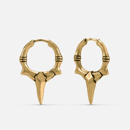 Gold-tone Primal Blade Earrings feature a dagger blade hoop silhouette and an antiqued finish.