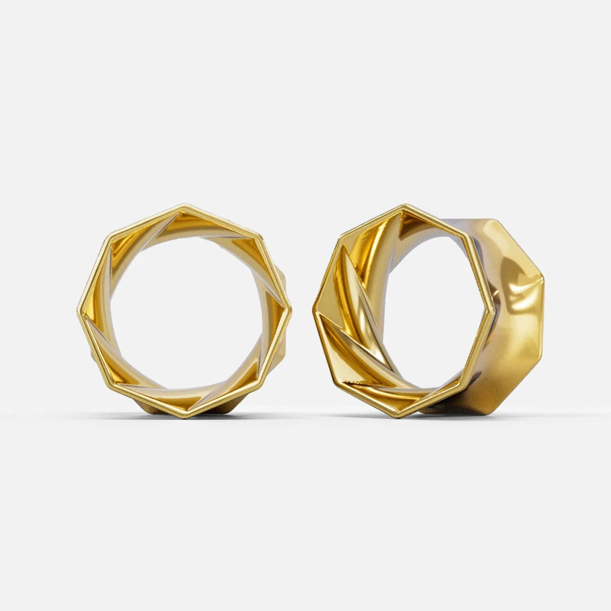 Two gold-tone faceted tunnel earrings with angular ridged edges shown standing upright side by side