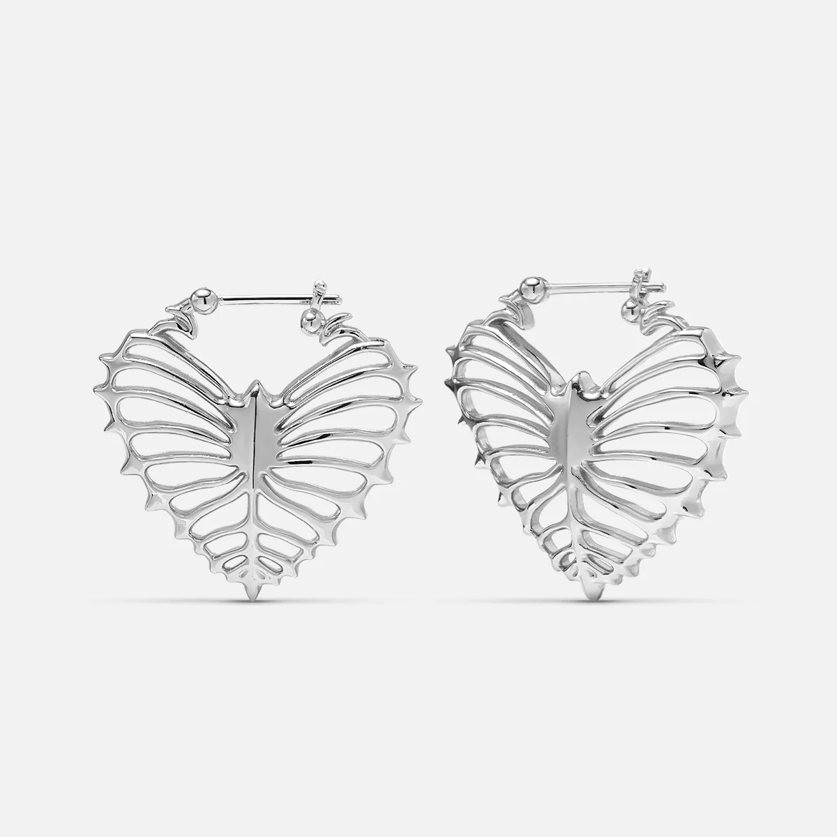 Silver-tone ribheart earrings pair with heart-shaped rib cage design, front view on white background