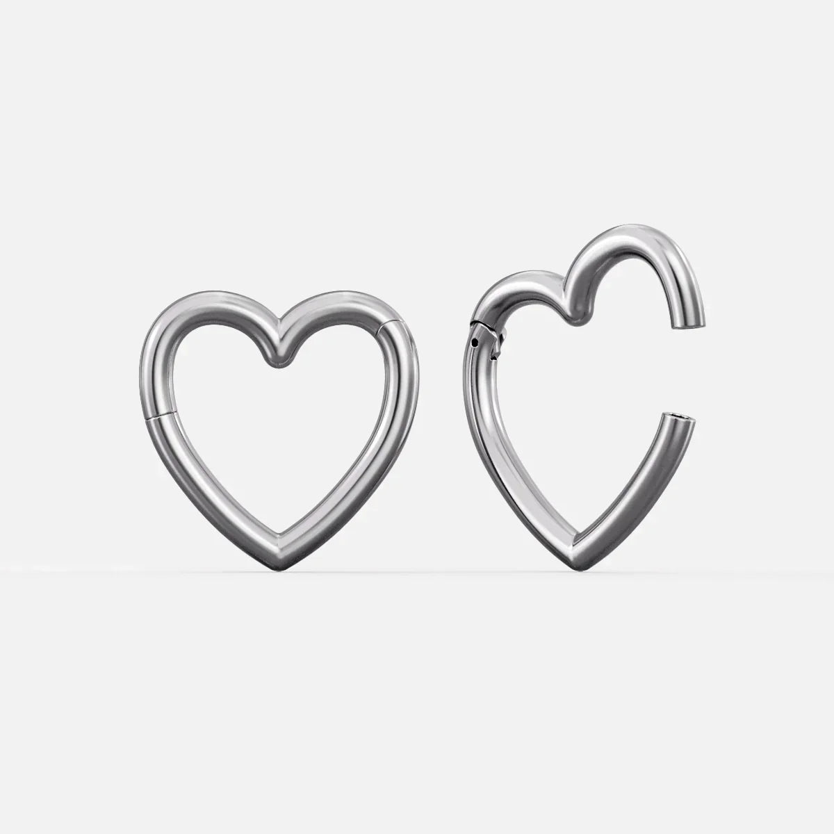 Silver-tone heart-shaped hinged ear weights, one closed and one open showing the clasp