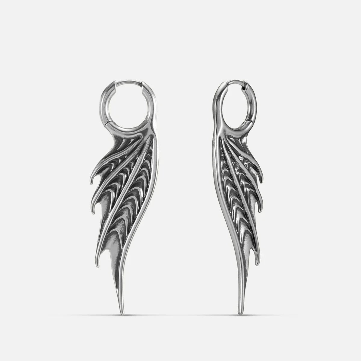 Silver Spined Wing Earrings with long ribbed wing drops, sharp fin-like ridges, and hoop design on a clean background.
