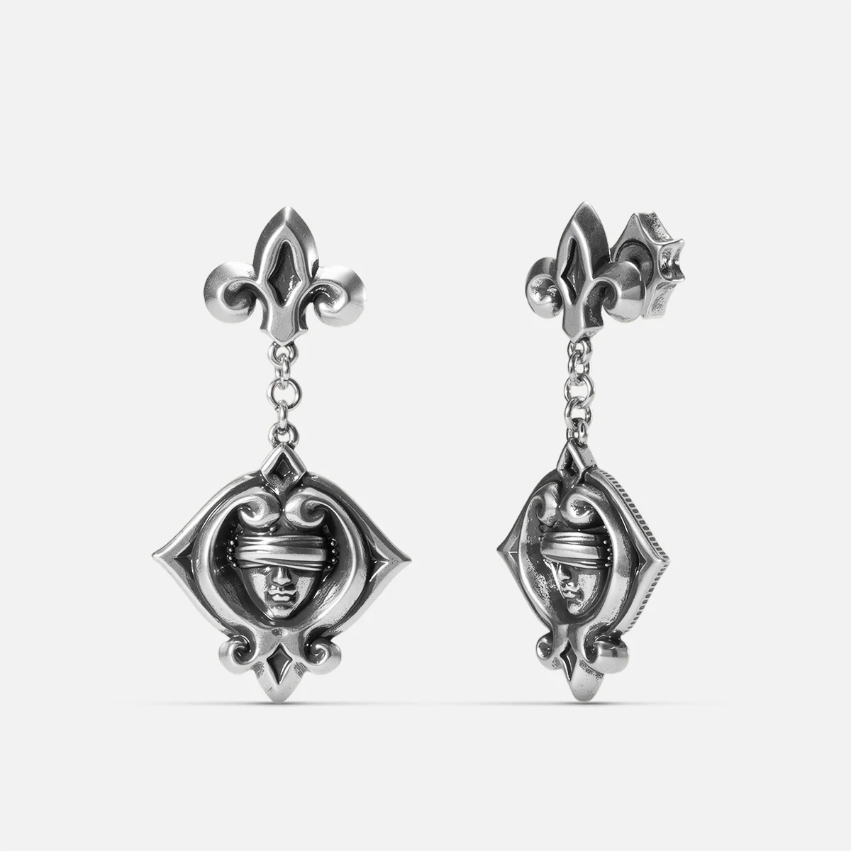 Antiqued silver-tone Veiled Seer Drop Earrings shown from front and side views with blindfolded face motifs, pointed eye-shaped frames, and fleur-de-lis studs.