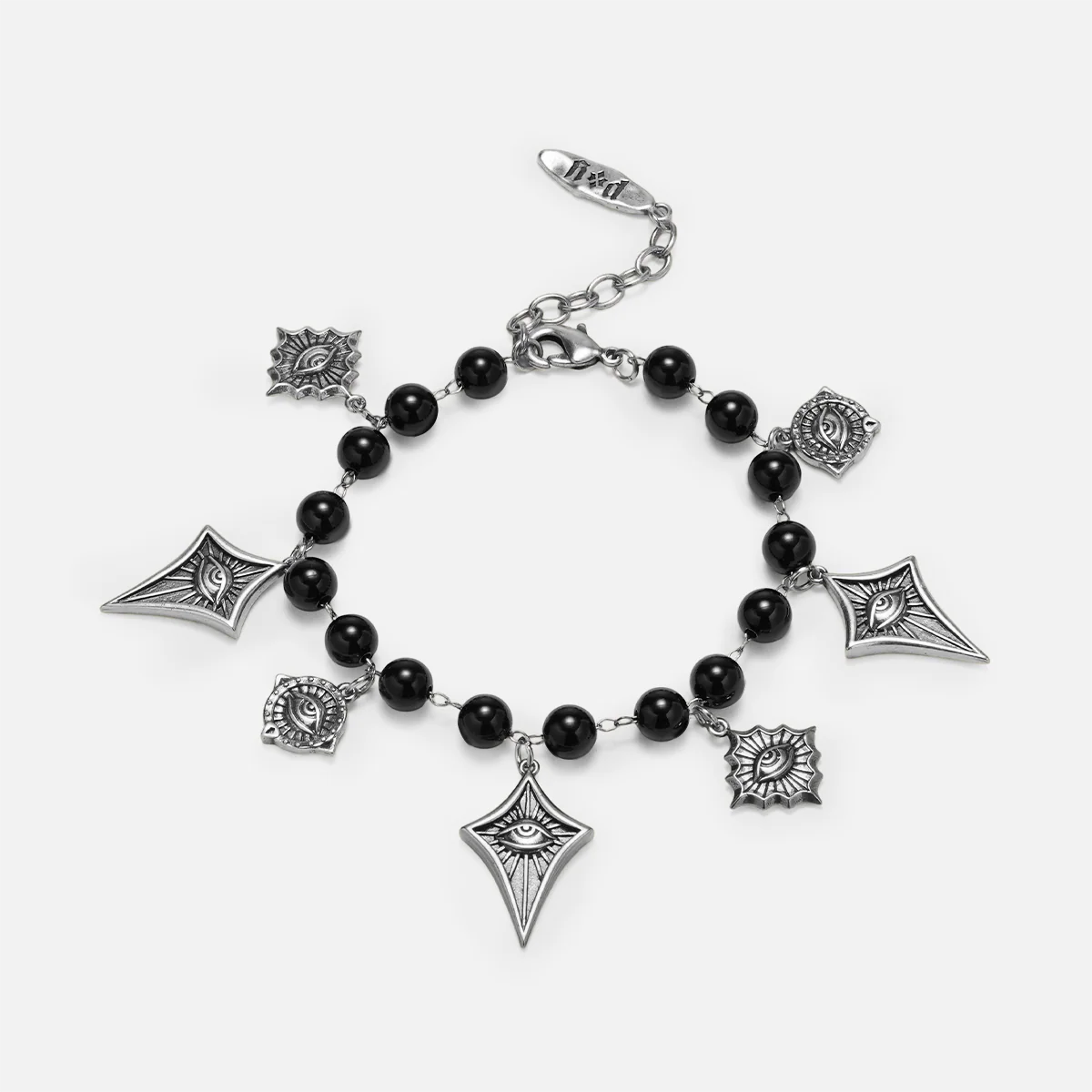 A gothic-style charm bracelet featuring black beads and silver-toned charms, including eye motifs, kites, and sunbursts, displayed on a light gray background.